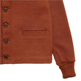 Close up of bottom hem, buttons, front pocket, and sleeve opening