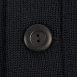 Close-up of a black button on black knit fabric