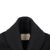 Close-up of a black sweater with a visible label on a white background