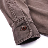 Close up of the sleeve of a brown utility shirt. The button on the sleeve cuff reads “Freenote”