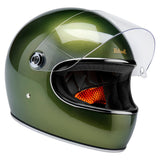 Angled profile of Gringo S helmet in metallic dart green with clear visor up and inner lining visible