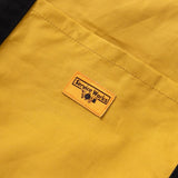 Close up of Service Works label on tote in yellow ochre