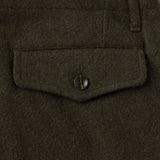 Close up of back pocket of a pair of dark olive green wool trousers with a button-secured flap