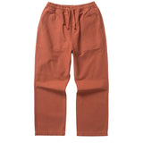 Front of a pair of deep orange straight leg pants with fatigue-style pockets and a drawstring waist