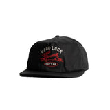 Black baseball cap facing forward and slightly angled to the side with embroidery in white and red of a leaping rabbit with text [Good Luck Don't Die]