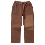 Front view of straight leg canvas pants in colorblocked shades of brown with a drawstring waist. There is a hammer loop on the side of the wearer's left pant leg. 