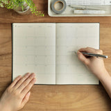 Top down view of open planner being written in